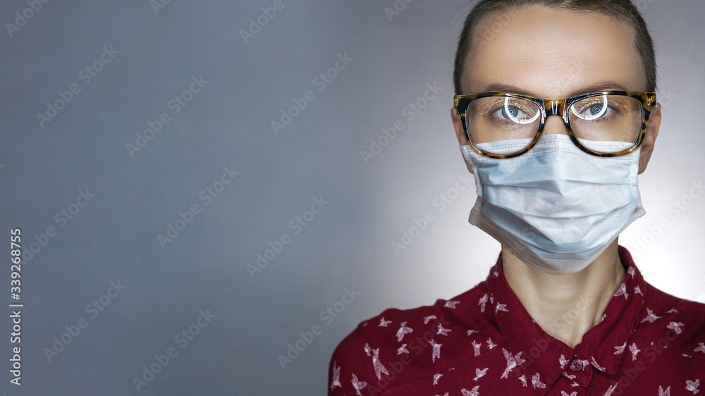 Beautiful young woman wearing glasses and protective mask over grey background