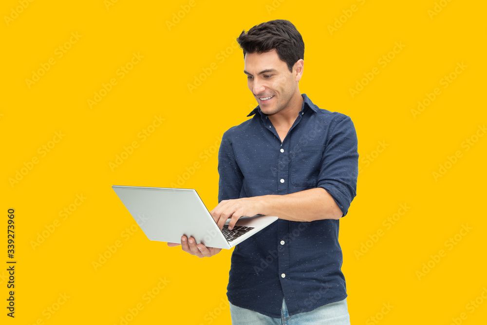 Portrait of an excited man holding laptop computer isolated on yellow background, Feeling happiness, Caucasian Male model - obrazy, fototapety, plakaty 