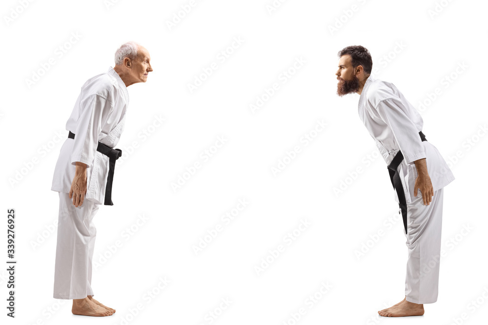 Karate masters with black belts bowing