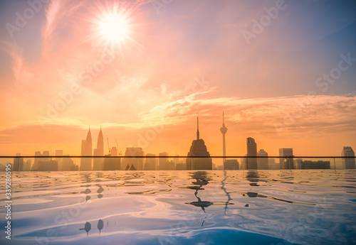 Photography Cityscape of Kuala lumpur city skyline with swimming pool on the roof top of hotel at sunrise in Malaysia
