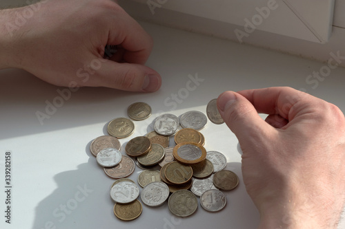 A man counts money and divides it. Round coins. 