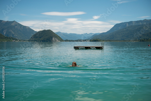 Foto Young woman swimming in lake during sunny day