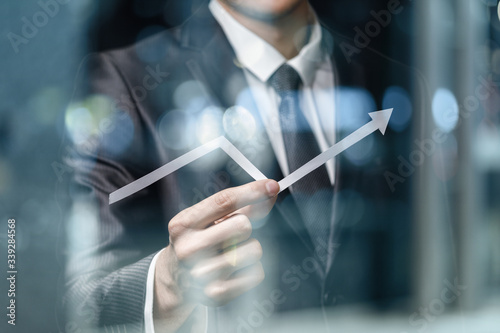 Young businessman shows an arrow of financial growth .