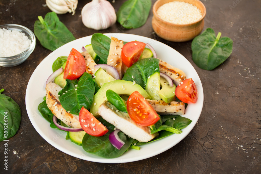 Grilled chicken breast with avocado and herbs on a dark background. Dietary nutrition. Healthy food. Side view. Close-up. Grilled chicken breast with avocado and herbs on a dark background. Dietary nutrition. Healthy food. Side view. Close-up.
