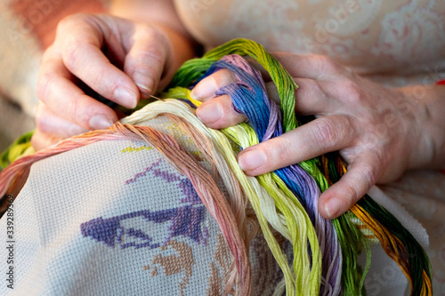 women's hands hold colored threads for embroidery, needlework, creativity, handmade work.