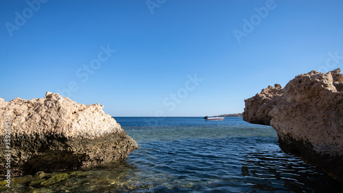 Sharm el Sheikh red sea coastline. High cliffs and a motorboat in the sea.