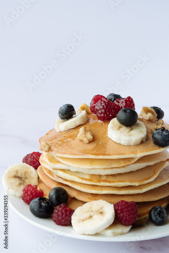 breakfast, pancakes with raspberry, blueberry, nuts, banana and honey