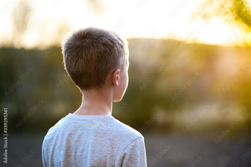 Child boy standing outdoors on summer sunny day enjoying warm weather outside. Rest and wellness concept. Child boy standing outdoors on summer sunny day enjoying warm weather outside. Rest and wellness concept.