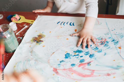 Indoor picture of a child painting with hands