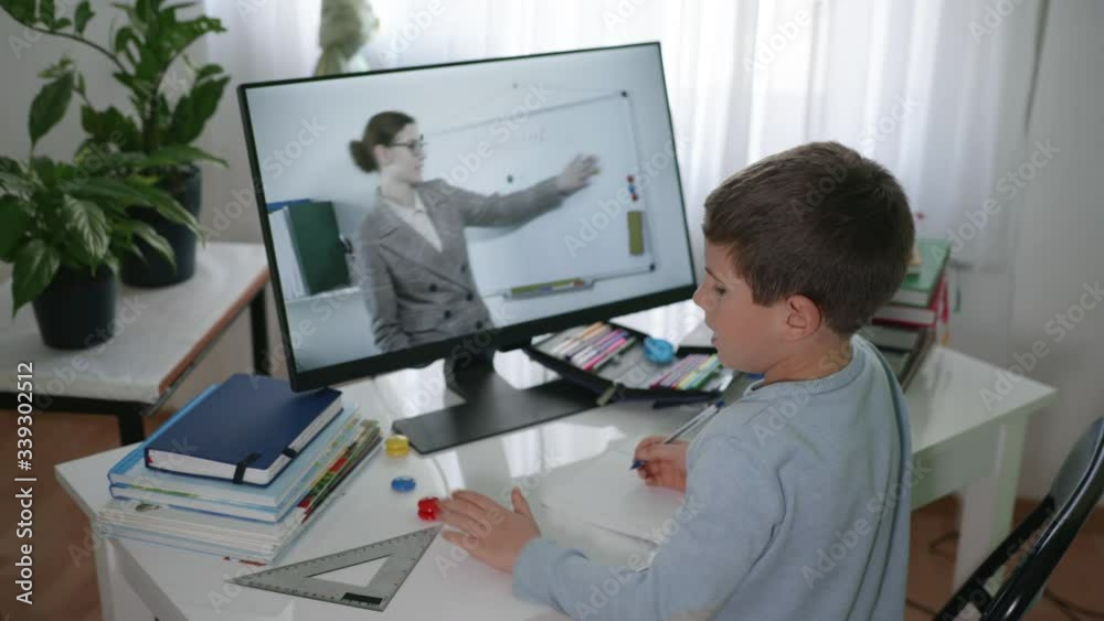 remote education, male school child learns lessons online using video broadcasting and modern technologies, looks at monitor screen and does homework, learning online remote education, male school child learns lessons online using video broadcasting and modern technologies, looks at monitor screen and does homework, learning online