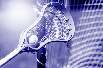Abstract view of a lacrosse stick scooping up a ball. Sunny day. Phantom color trend