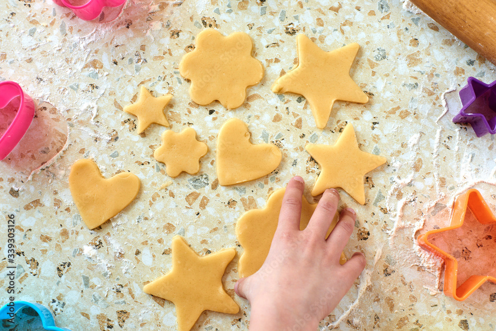 A child with his mother makes cookies, rolls out the dough and uses forms to make cookies. A child with his mother makes cookies, rolls out the dough and uses forms to make cookies.