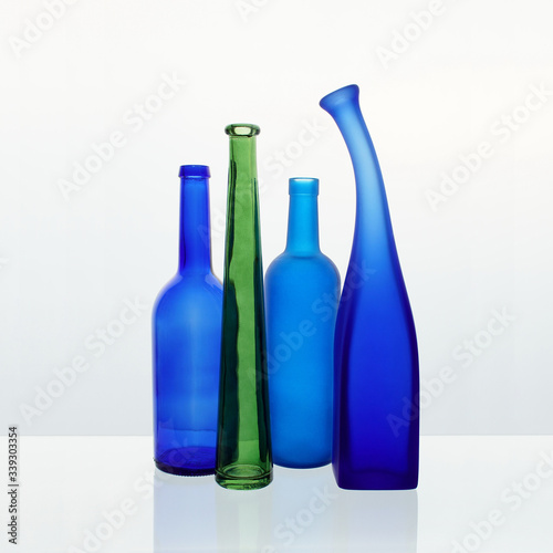Still life with colored bottles on a white background