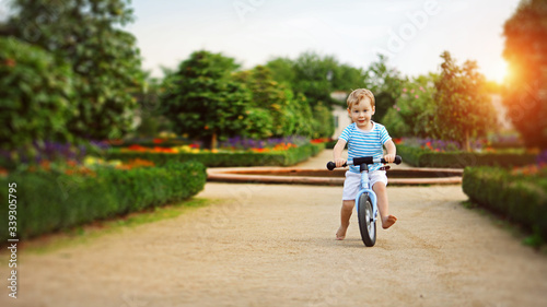  happy child boy rides a racetrack in Park in summer
