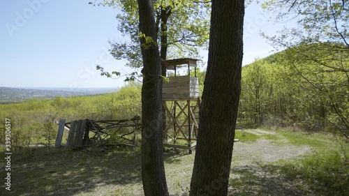 Lookout wooden watch tower for hunters, gimbal 4K shot in colorful forest.  photo