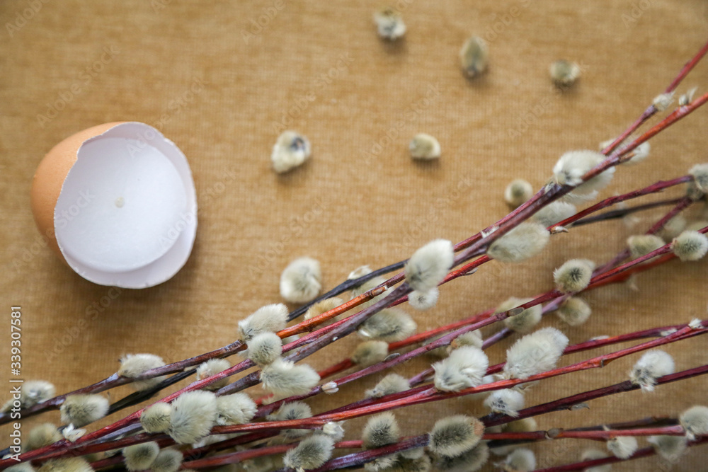 cream background a willow branch and an eggshell with a candle cream background a willow branch and an eggshell with a candle