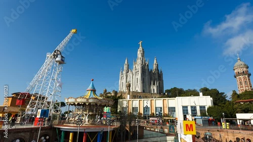 Amusement park on Tibidabo hill on the background of Sacred Heart of Jesus Church photo
