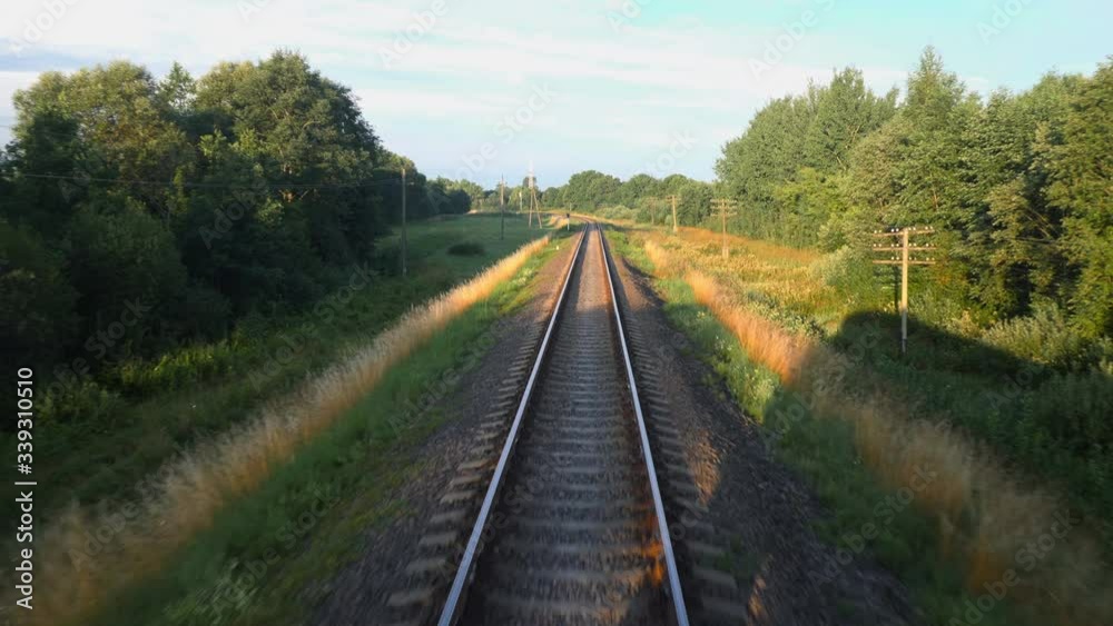 Back view of railroad and a beautiful green nature from a train passing on countryside land. Railroad travel or railway tourism concept. Slow motion back view 4K video. Back view of railroad and a beautiful green nature from a train passing on countryside land. Railroad travel or railway tourism concept. Slow motion back view 4K video.