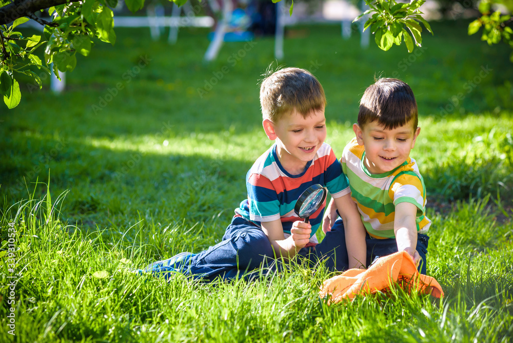 Adorable kid boy making fire on paper with a magnifying glass outdoors, on sunny day. Adorable kid boy making fire on paper with a magnifying glass outdoors, on sunny day.