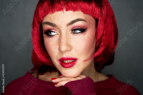 Portrait of an attractive girl with shiny glitter freckles and a bright pink wig on a background. Holiday and party style. Beauty  makeup and cosmetics concept.