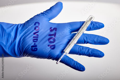 medical blue rubber glove with the inscription stop covid19