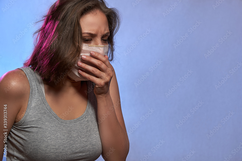 Covid-19 Pandemic Coronavirus. Girl with protective mask on face. Woman isolated on the light background in studio Covid-19 Pandemic Coronavirus. Girl with protective mask on face. Woman isolated on the light background in studio