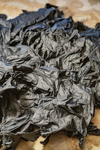 A messy pile of disposable black latex medical gloves