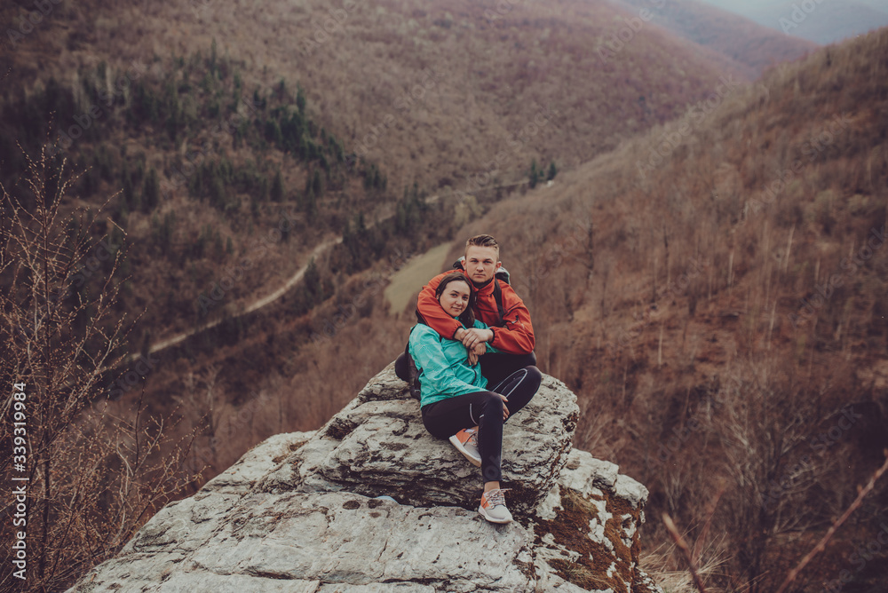Young couple sitting near the cliff
