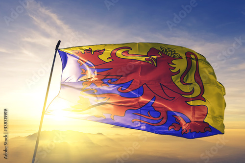 Sint-Truiden of Limburg of Belgium flag waving on the top sunrise mist fog