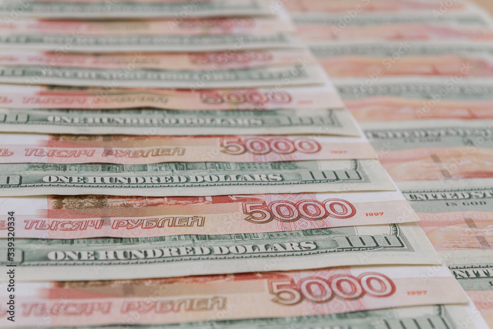Fototapeta premium A large number of American hundred dollar bills and Russian five thousand dollar bills