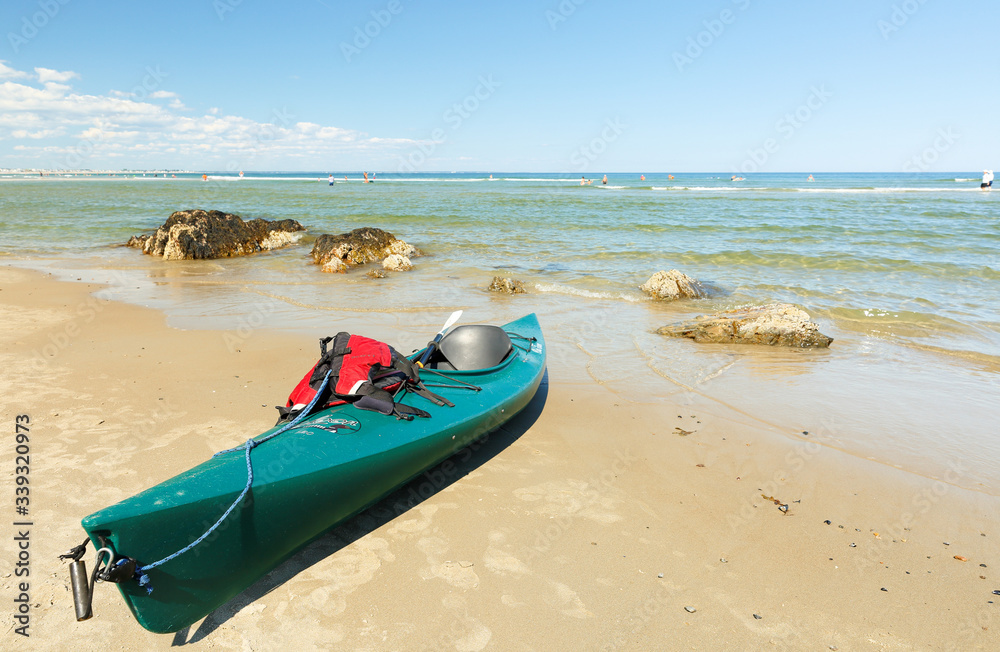 A Green Kayak Docking on the Ogunquit Beach, Maine. Ogunquit was named by the Abenaki tribe, because the word means A Green Kayak Docking on the Ogunquit Beach, Maine. Ogunquit was named by the Abenaki tribe, because the word means