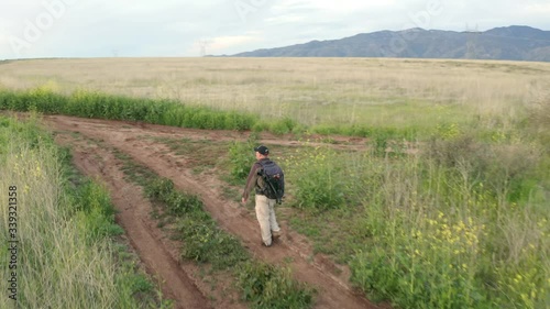 Wallpaper Mural Flying over a man hiking through an endless prairie on a rural dirt road in the Aqua Fria National Monument in Arizona. Torontodigital.ca