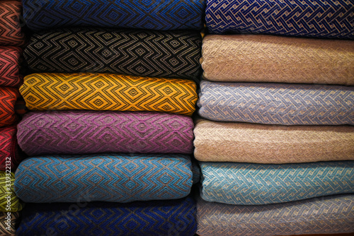 stacked multicolored clothing fabric in the closet bed linen banner.