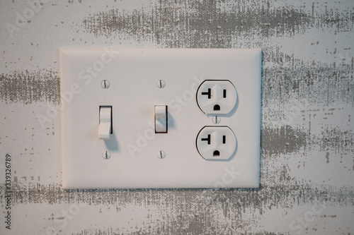 Electrical outlet socket with light switches and grounded North American plugs.