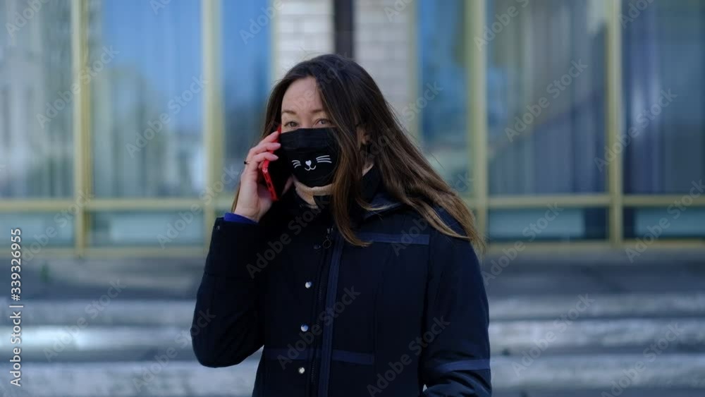 girl in medical mask speaks on smartphone girl in medical mask speaks on smartphone