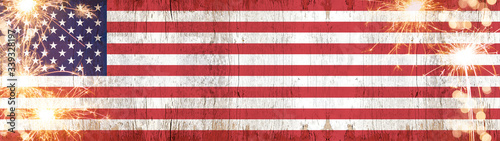 Happy 4th of July background panorama banner - American flag on wooden rustic vintage texture with sparklers and firework © Corri Seizinger