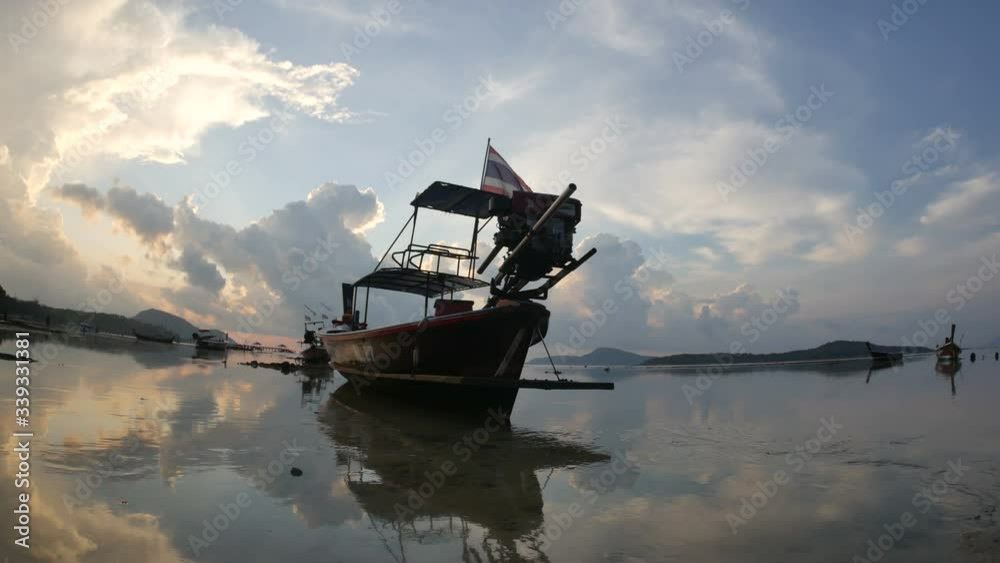 moving thai flag on long tail fishing boat mooing on low tide water, flowing water, cloud reflection in water, island mountain long distance, cloudy colorful sky in morning time, fish-eye lens view moving thai flag on long tail fishing boat mooing on low tide water, flowing water, cloud reflection in water, island mountain long distance, cloudy colorful sky in morning time, fish-eye lens view