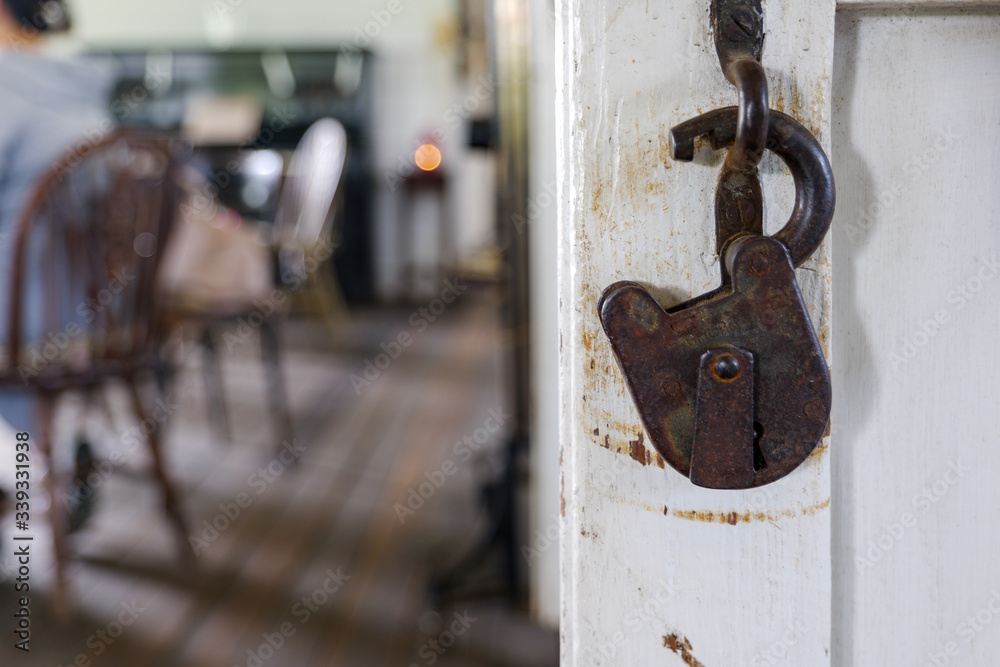 Selected focus and close up view at old rusty vintage retro design of lock hang on white wooden door. Selected focus and close up view at old rusty vintage retro design of lock hang on white wooden door.