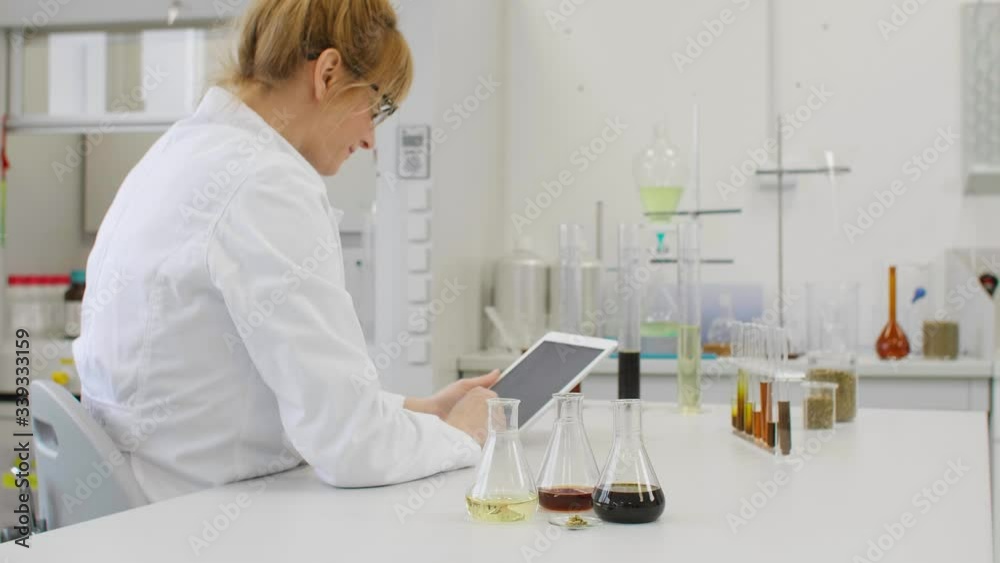 Close up of chemist working with hemp CBD oil and tablet in laboratory Close up of chemist working with hemp CBD oil and tablet in laboratory