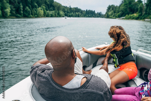 Dad and daughter on boat in lake surrounded by trees 