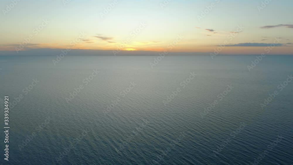 Slow aerial descend over calm ocean water at dusk Slow aerial descend over calm ocean water at dusk
