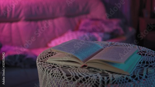 the book is lying on the table in a colored light.behind her is a TV that doesn't work.the frame is getting closer, the diary is getting better and getting bigger according to the plan