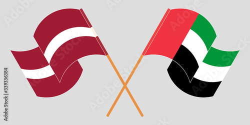 Crossed and waving flags of Latvia and the United Arab Emirates