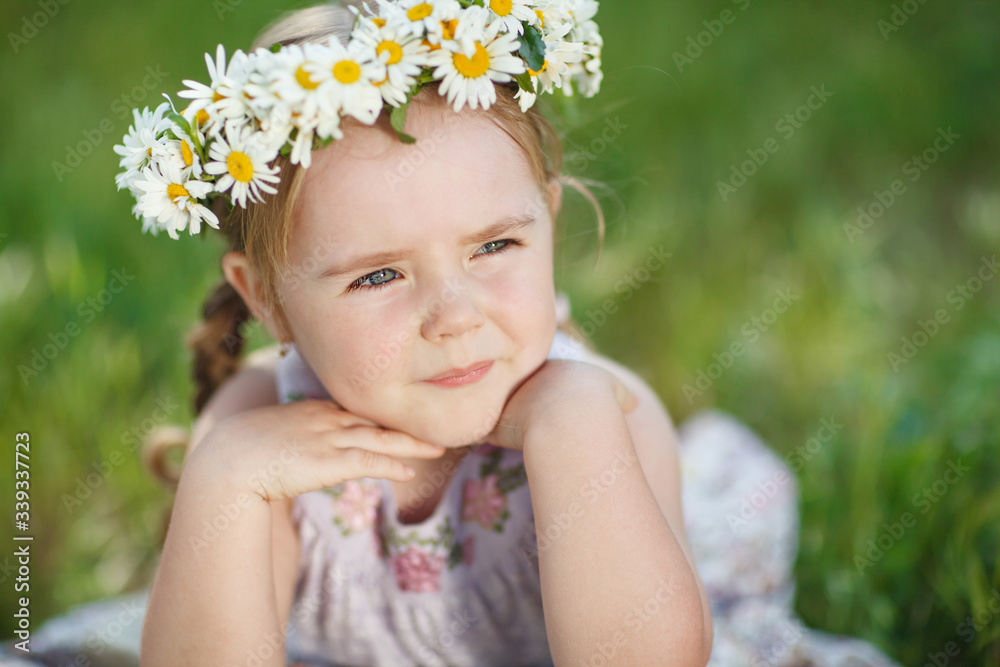 Little girl in nature with a wreath of flowers on her head. Little girl in nature with a wreath of flowers on her head.
