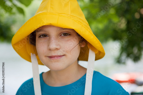 Girl wearing a yellow rain hat in backyard just in case it rains 
