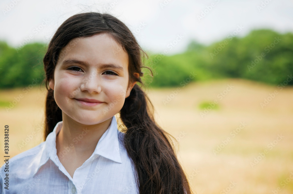 Portrait of girl out doors by field smiling at camera Portrait of girl out doors by field smiling at camera