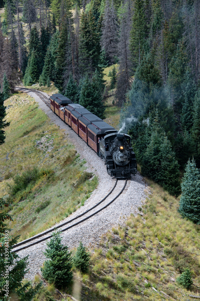 Fototapeta premium Historic Cumbres Toltec narrow-gauge train engine chugging up the mountain going north to Antonito, Colorado railroad station