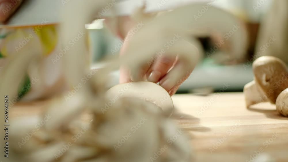hands chopping fresh mushrooms on a cutting board then throws the mushrooms with a knife. fast.