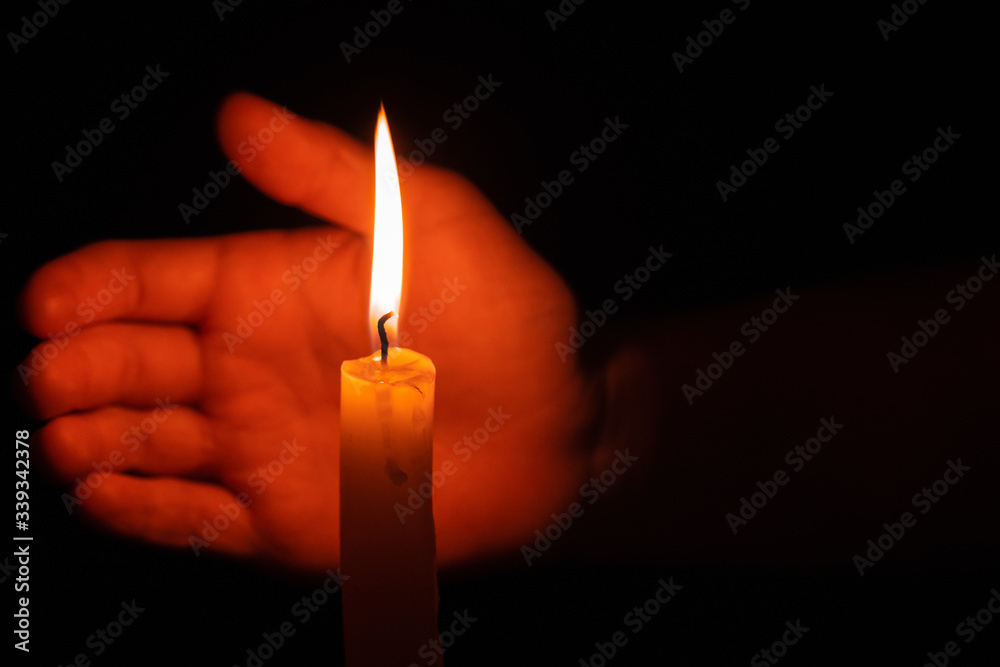 Concept of tragedy or requiem. Memorial service for dead and deceased. Rite in church, memorial service. Sorrow, loss. Ceremony with burning candle in hand in dark Concept of tragedy or requiem. Memorial service for dead and deceased. Rite in church, memorial service. Sorrow, loss. Ceremony with burning candle in hand in dark