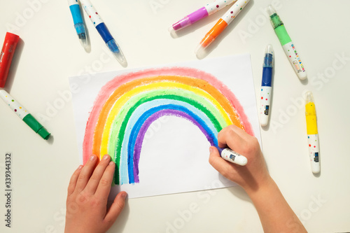 Top view of a boy drawing a rainbow photo